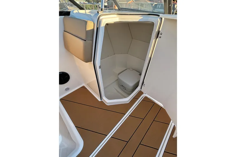 Slide: The Image of 2026 Bayliner D22 boat interior with compact toilet and cushioned seating. - 17
