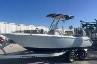 Slide: The Image of 2023 Key West 203 FS boat on trailer, parked outdoors under clear blue sky. - 5