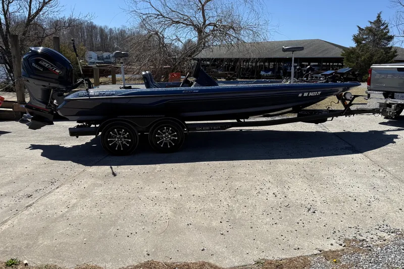 Slide: The Image of 2023 Skeeter ZXR21 boat on trailer with Yamaha engine, parked outdoors. - 9
