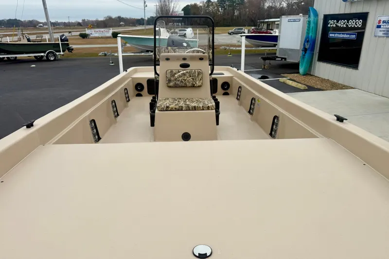 Slide: The Image of 2026 Carolina Skiff E21 DLX CC boat with camo seating, displayed outdoors. - 10