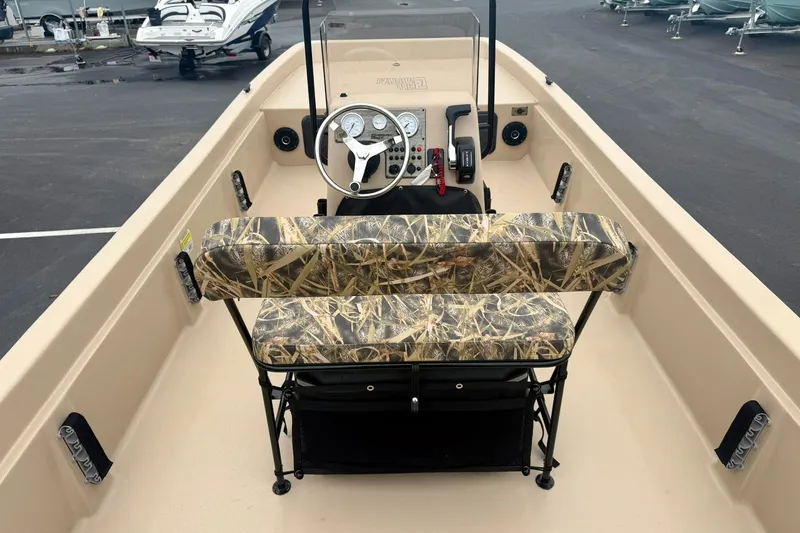 Slide: The Image of 2026 Carolina Skiff E21 DLX CC boat interior with camo seating and steering console. - 22