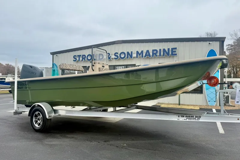 Slide: The Image of 2026 Carolina Skiff E21 DLX CC boat on trailer at Stroud & Son Marine dealership. - 4
