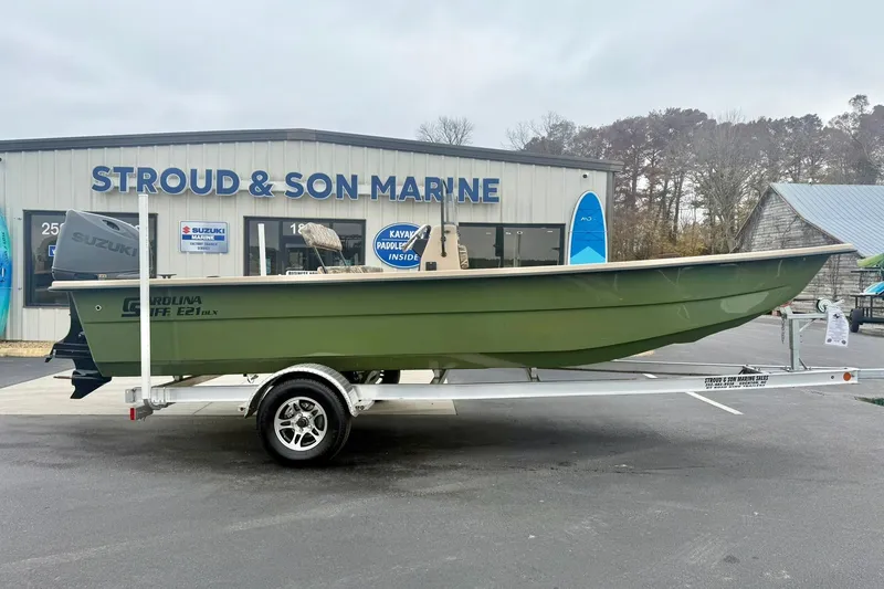 Slide: The Image of 2026 Carolina Skiff E21 DLX CC boat on trailer at Stroud & Son Marine dealership. - 7