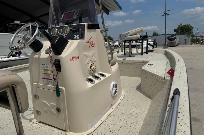 Slide: The Image of Xpress H20 boat interior, steering console, and equipment, 2015 model, in a marina setting. - 13