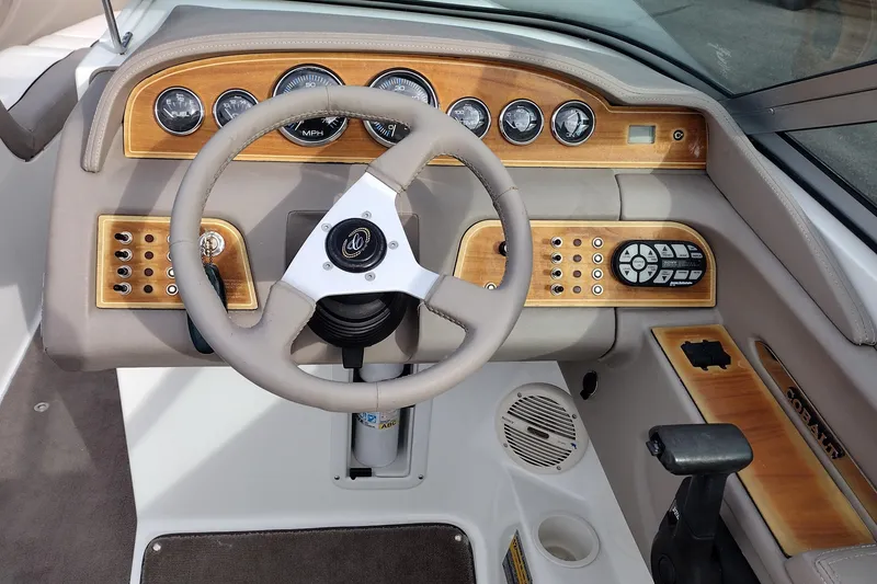 Slide: The Image of Steering wheel and dashboard of a 2000 Cobalt 246 boat with wood accents. - 12