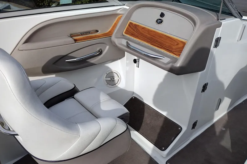 Slide: The Image of Interior of a 2000 Cobalt 246 boat featuring a sleek seat and wood-accented dashboard. - 21