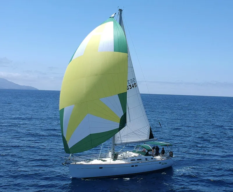 Slide: The Image of 2004 Beneteau 473 sailboat with colorful spinnaker sailing on open sea. - 0
