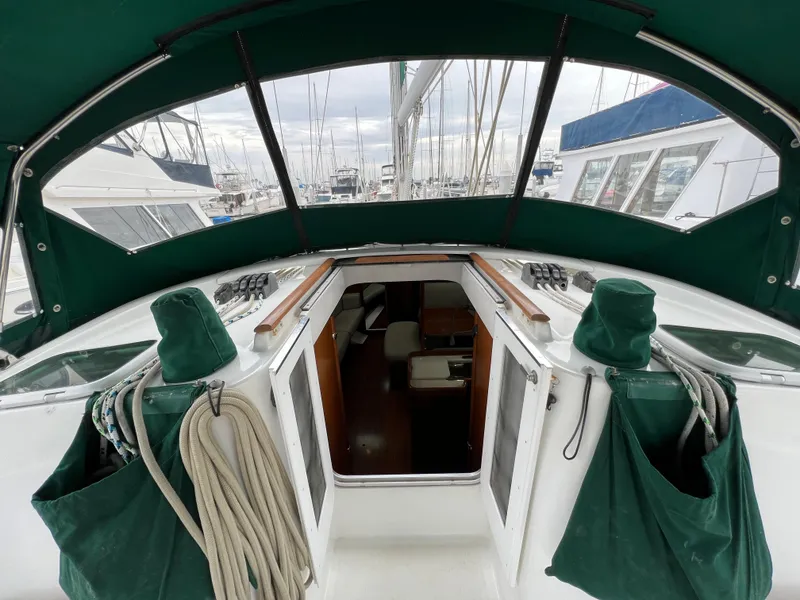 Slide: The Image of Cockpit view of 2004 Beneteau 473 sailboat with green canopy and open cabin entrance. - 17