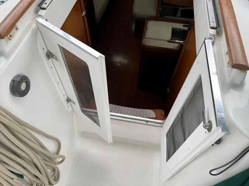Slide: The Image of 2004 Beneteau 473 yacht interior with open cabin doors and visible seating area. - 19