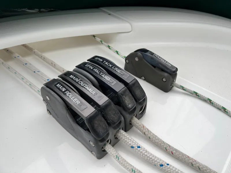Slide: The Image of Rope clutches on a 2004 Beneteau 473 sailboat deck, labeled for various sailing functions. - 22