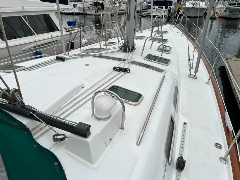 Slide: The Image of 2004 Beneteau 473 sailboat deck with hatches, docked at marina. - 23