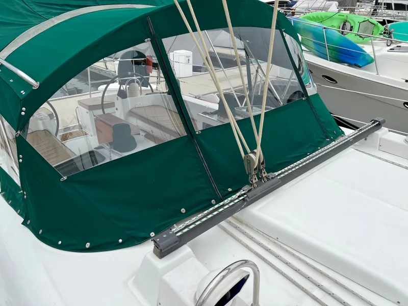 Slide: The Image of 2004 Beneteau 473 sailboat with green canopy, docked at marina. - 24