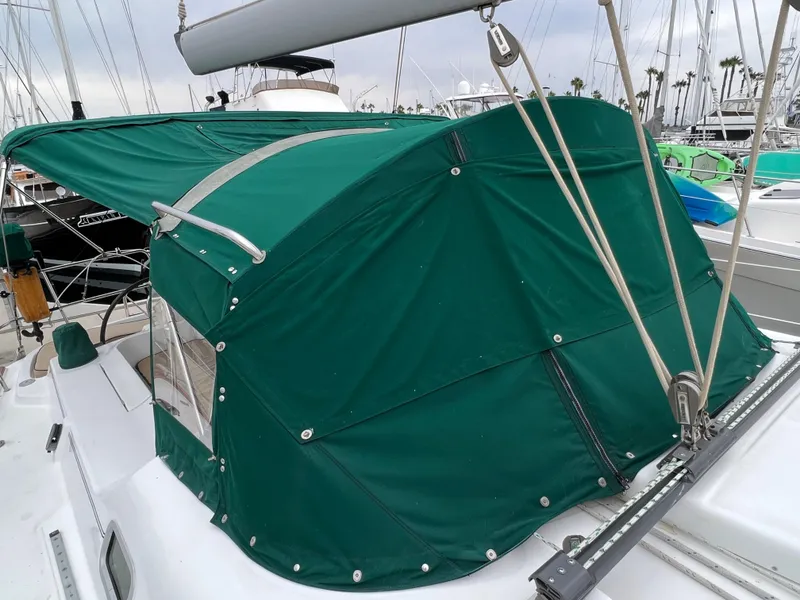 Slide: The Image of 2004 Beneteau 473 sailboat with green canvas cover in marina setting. - 25