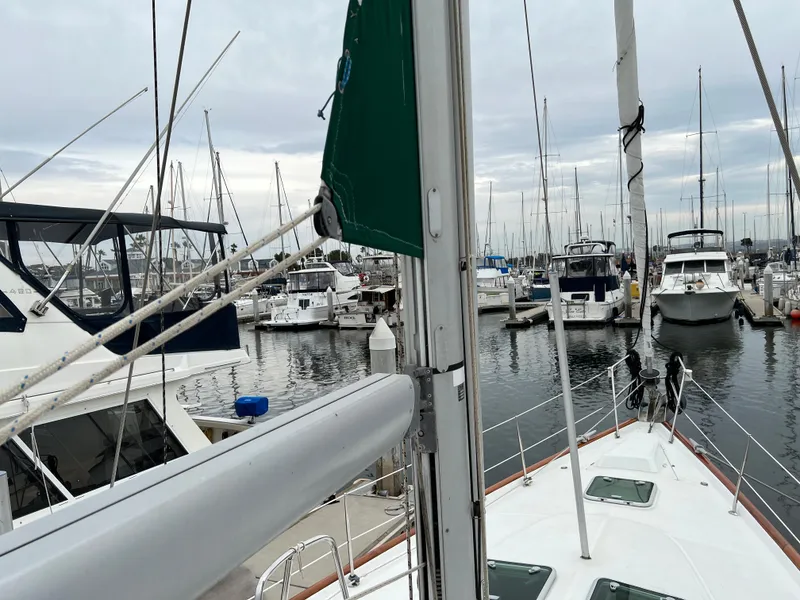 Slide: The Image of 2004 Beneteau 473 sailboat docked in a marina with other boats. - 26