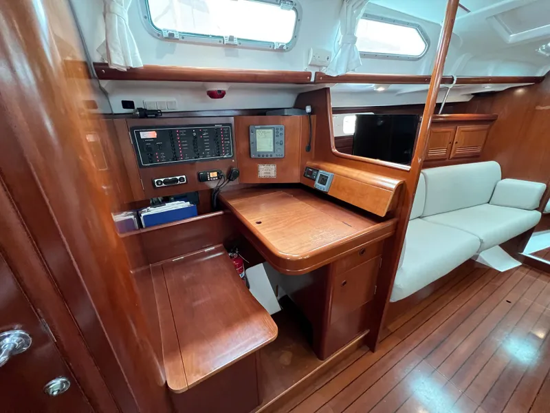 Slide: The Image of Interior of 2004 Beneteau 473 sailboat with navigation station and wooden furnishings. - 35