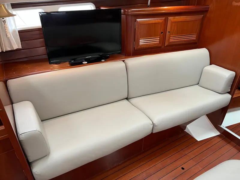 Slide: The Image of Luxurious interior of 2004 Beneteau 473 yacht with beige sofa and mounted TV. - 38