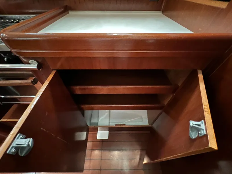 Slide: The Image of 2004 Beneteau 473 yacht interior with open wooden cabinet and shelves. - 45