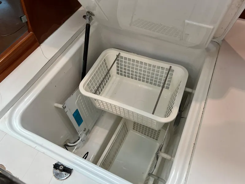 Slide: The Image of Open storage compartment with white baskets in a 2004 Beneteau 473 yacht. - 49