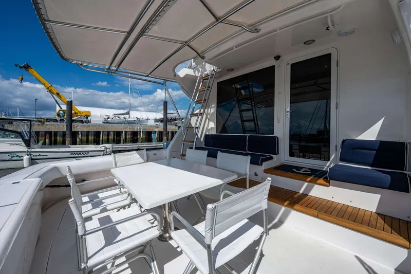 Slide: The Image of Luxury 2008 Bertram 570 yacht deck with seating and table, docked at marina. - 5