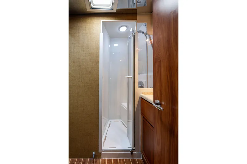 Slide: The Image of 2008 Bertram 570 yacht bathroom with shower, wooden cabinetry, and modern fixtures. - 42
