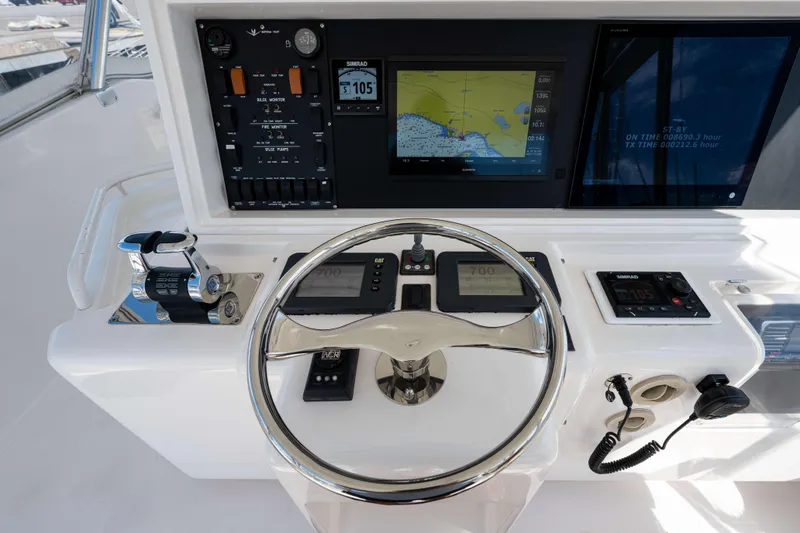 Slide: The Image of Control panel of a 2008 Bertram 570 yacht with navigation screens and steering wheel. - 18
