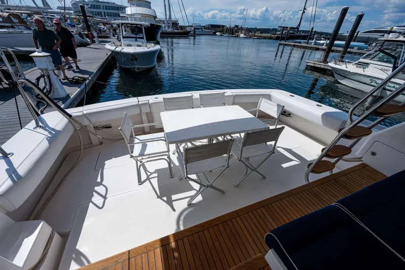 Slide: The Image of 2008 Bertram 570 yacht deck with table and chairs, docked at marina. - 9
