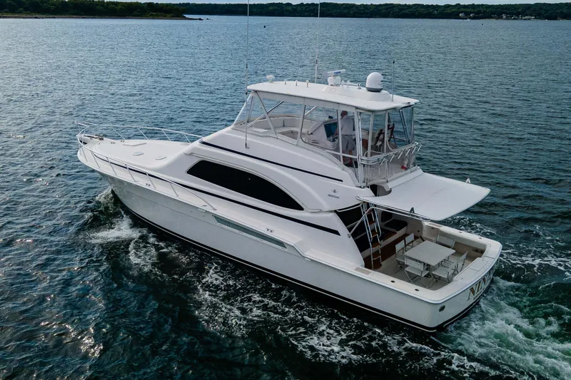 Slide: The Image of 2008 Bertram 570 yacht cruising on open water, showcasing sleek design and spacious deck. - 3