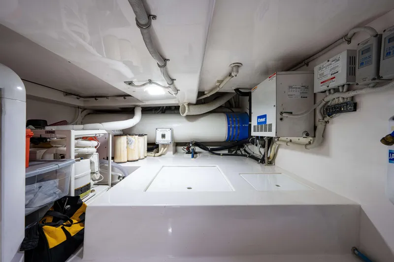 Slide: The Image of Engine room of a 2008 Bertram 570 yacht, featuring various mechanical components and storage. - 68