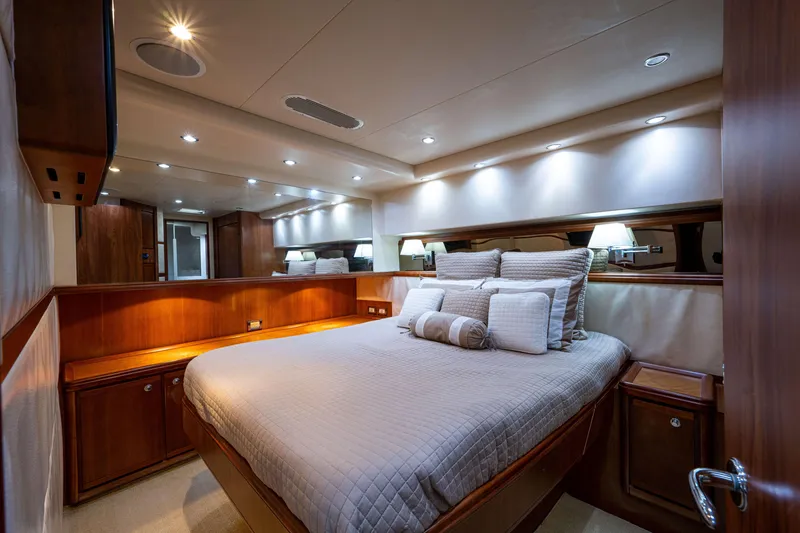 Slide: The Image of Luxurious bedroom interior of 2008 Bertram 570 yacht with elegant wood finishes and ambient lighting. - 52