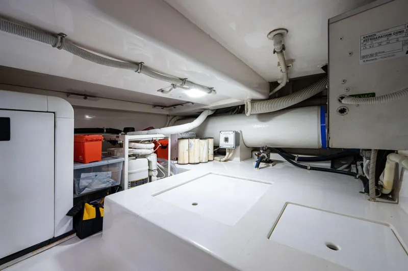Slide: The Image of Engine room of a 2008 Bertram 570 yacht, featuring storage and mechanical components. - 65