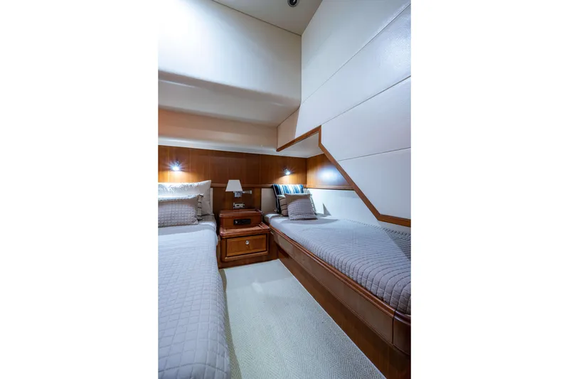 Slide: The Image of Luxurious 2008 Bertram 570 yacht cabin with twin beds and elegant wood paneling. - 47