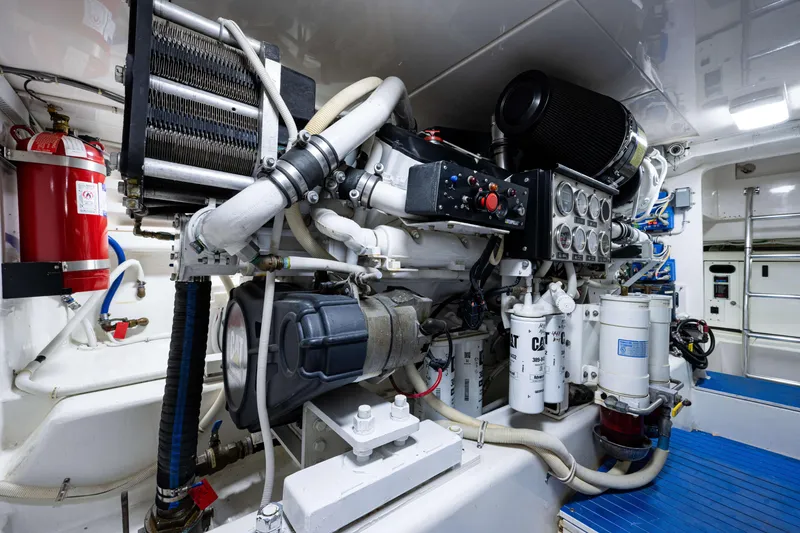 Slide: The Image of Engine room of a 2008 Bertram 570 yacht, featuring mechanical components and fire extinguisher. - 62