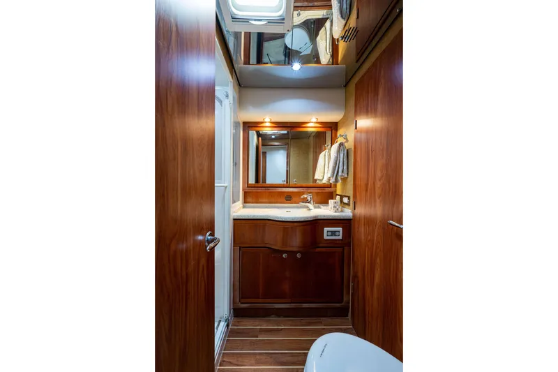 Slide: The Image of Luxurious 2008 Bertram 570 yacht bathroom with wooden cabinetry and modern fixtures. - 43