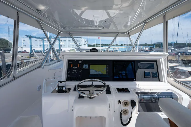 Slide: The Image of 2008 Bertram 570 yacht helm with advanced navigation systems and panoramic marina view. - 15