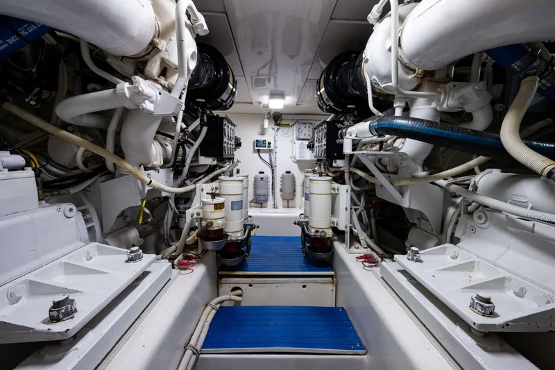 Slide: The Image of Engine room of a 2008 Bertram 570 yacht, showcasing complex machinery and piping. - 57