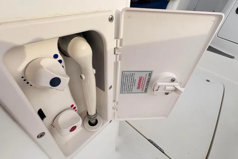Slide: The Image of 2007 Bayliner 285 boat shower controls with temperature knobs and warning label. - 13