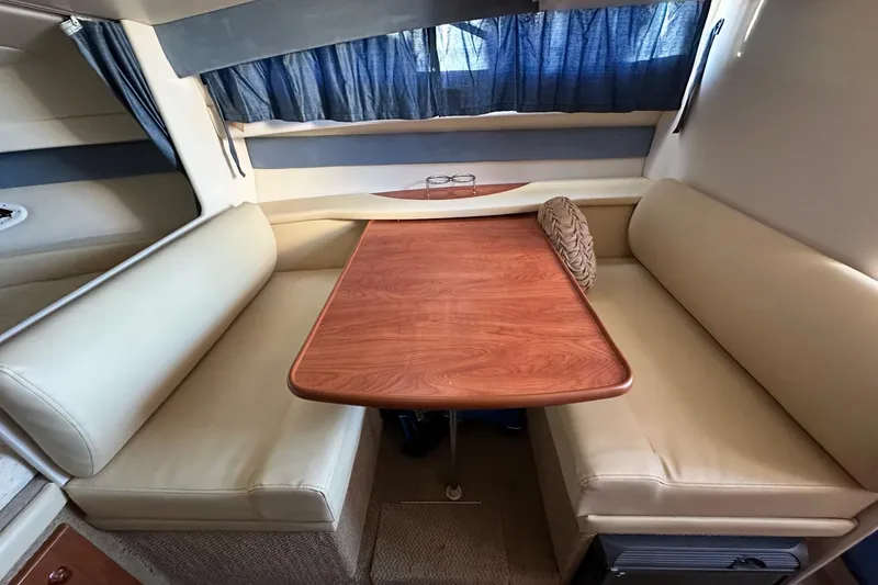 Slide: The Image of Interior of a 2007 Bayliner 285 boat with a cozy dining area. - 14