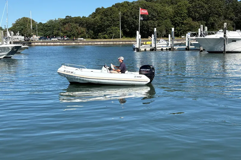 Slide: The Image of 2018 Mercury Inflatables M 400 HP boat on calm water near a marina. - 11