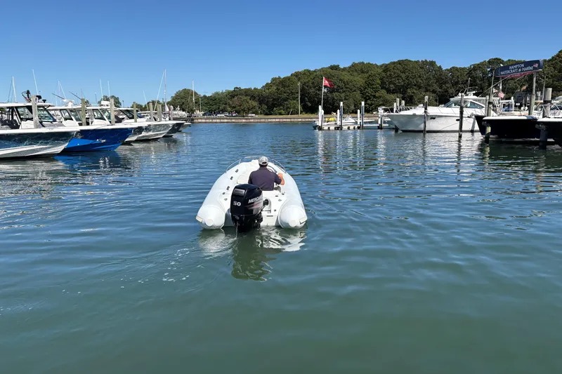 Slide: The Image of 2018 Mercury Inflatables M 400 HP boat navigating marina waters. - 2
