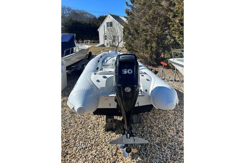 Slide: The Image of 2018 Mercury Inflatables M 400 HP boat with 50 HP outboard motor on gravel. - 4