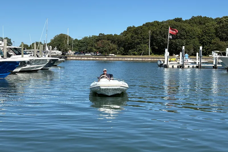 Slide: The Image of 2018 Mercury Inflatables M 400 HP boat on gravel lot, surrounded by other boats. - 9