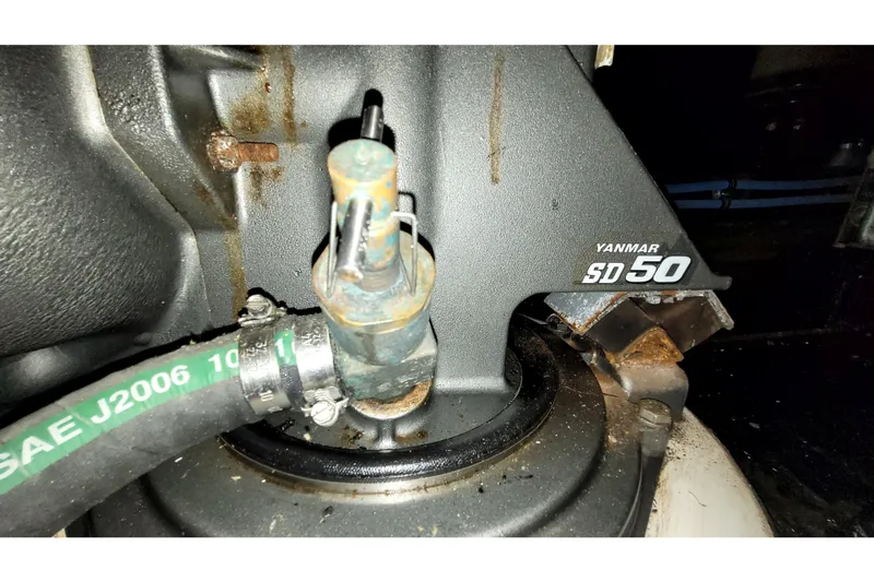 Slide: The Image of Close-up of Yanmar SD50 engine component with hose, showing rust and wear. - 55