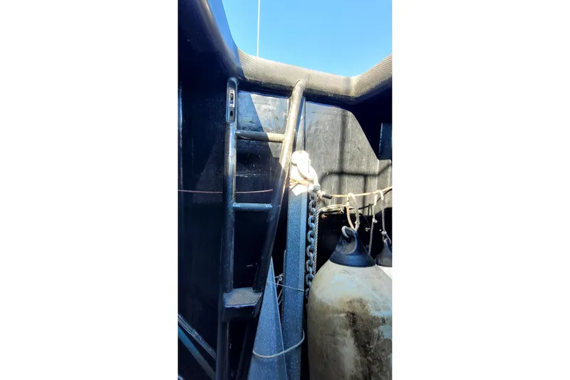 Slide: The Image of Interior view of a 2002 Custom International Americas Cup Class yacht, featuring equipment and ropes. - 76