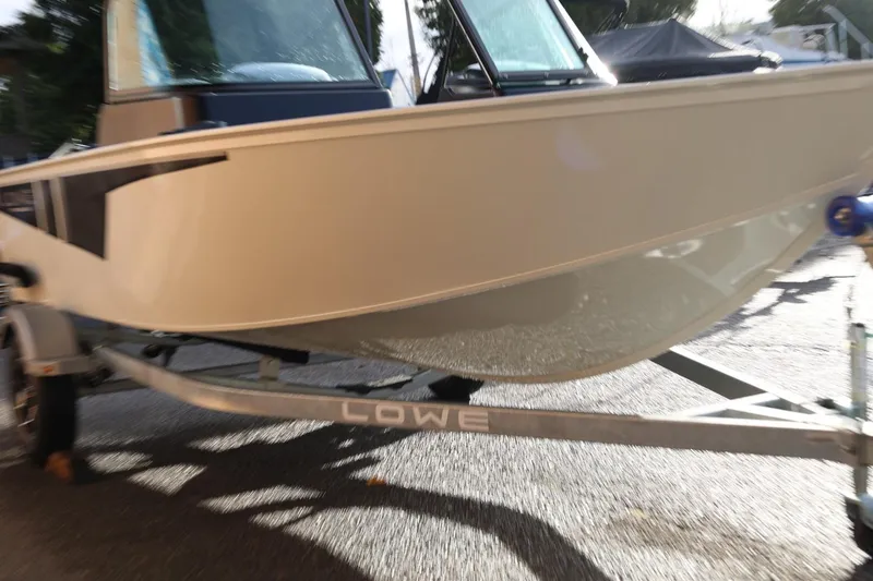 Slide: The Image of 2026 Lowe Fishing Machine 1675 WT on trailer, side view in sunlight. - 10