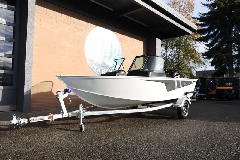Slide: The Image of 2026 Lowe Fishing Machine 1675 WT boat on trailer outside a building. - 15