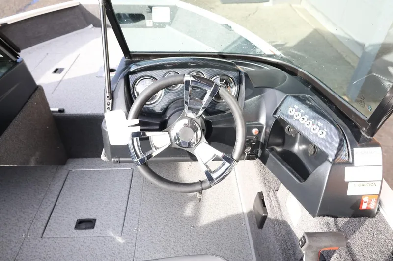 Slide: The Image of 2026 Lowe Fishing Machine 1675 WT boat dashboard with steering wheel and controls. - 21