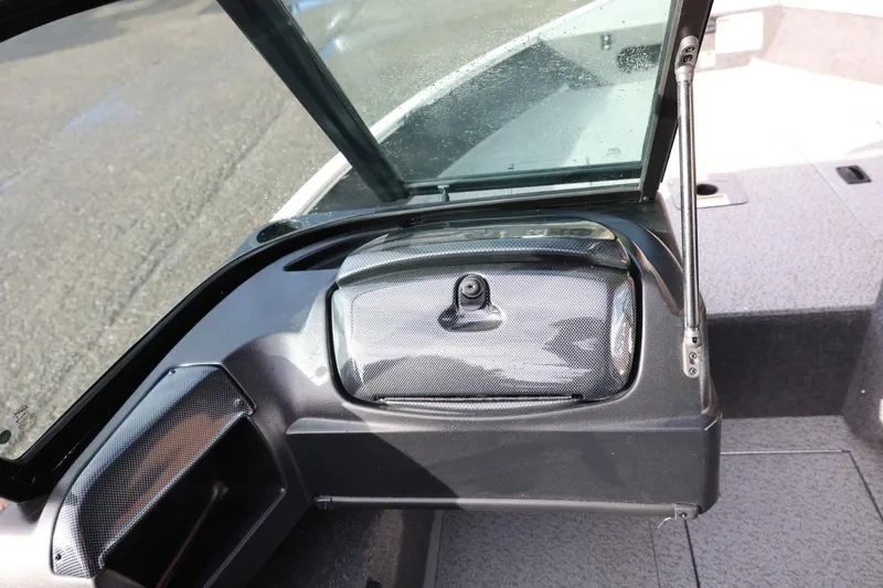 Slide: The Image of 2026 Lowe Fishing Machine 1675 WT dashboard with open windshield and storage compartment. - 26