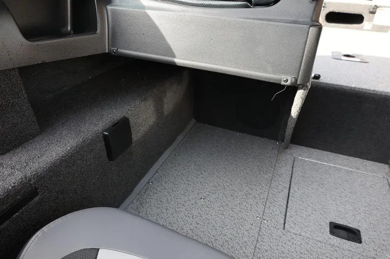 Slide: The Image of 2026 Lowe Fishing Machine 1675 WT interior, featuring carpeted flooring and storage compartments. - 28