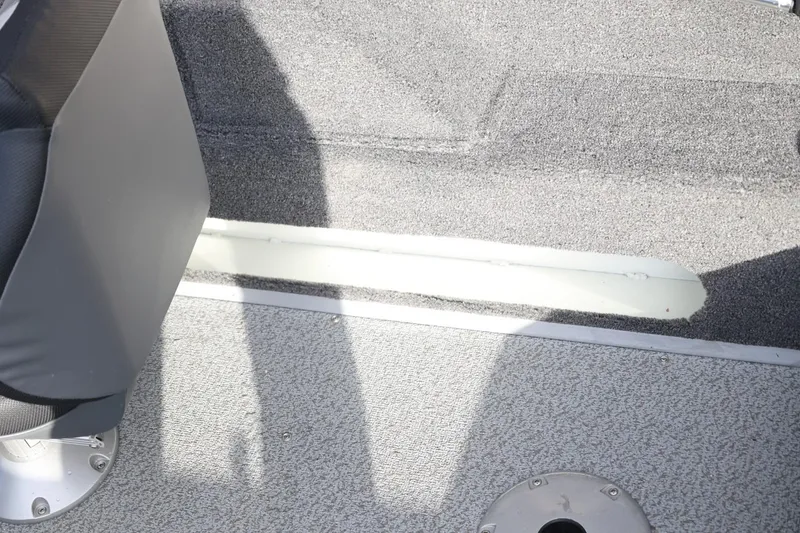 Slide: The Image of Interior of 2026 Lowe Fishing Machine 1675 WT boat, featuring carpeted flooring and seating. - 38