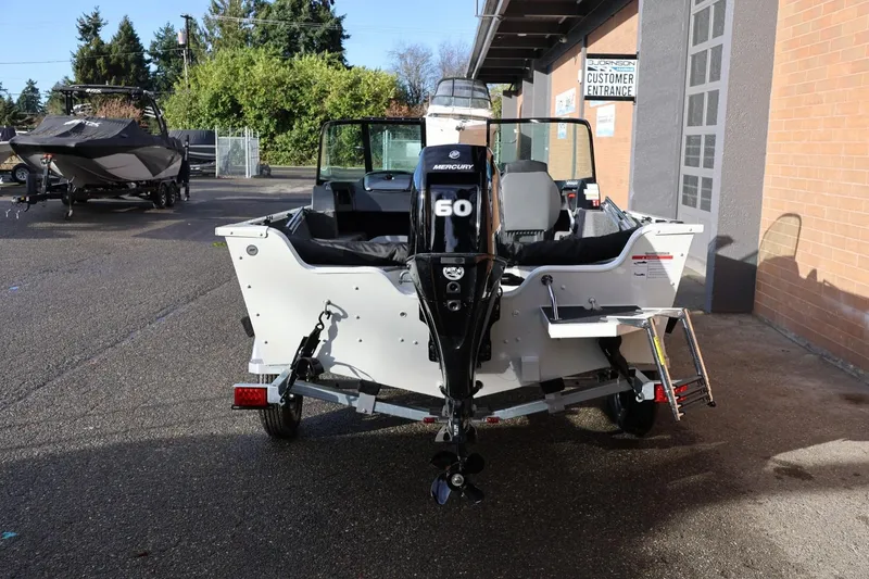 Slide: The Image of 2026 Lowe Fishing Machine 1675 WT with Mercury 60 engine, parked outside a building. - 5